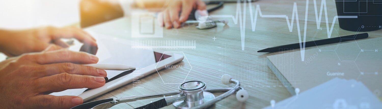 Zwei Menschen sitzen vor Tablet und Laptop, daneben liegt ein Stethoskop. Außerdem liegen die Skizze eines EKG über dem Bild